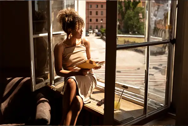 Mulher pensativa na janela - vunerabilidade